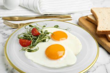 Tasty fried eggs with tomato and sprouts on white marble table, closeup