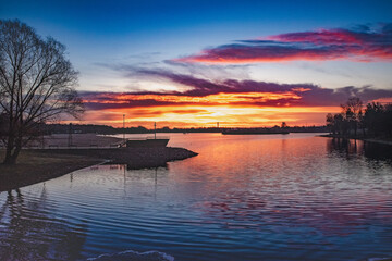 Coloured sunrise at the lake, boat in the sunset