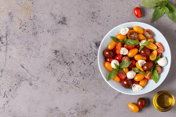 Italian caprese salad with tomatoes, mozzarella cheese, basil, olive oil.