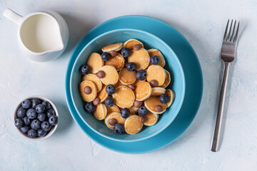 Trendy breakfast with mini pancakes, blueberries and chocolate chips.