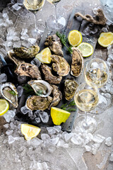 top view of delicious oysters on ice cubes and wine glass