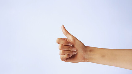 Female hand show thumbs up gesture. Woman hand rise OK good sign closeup isolated at white screen background