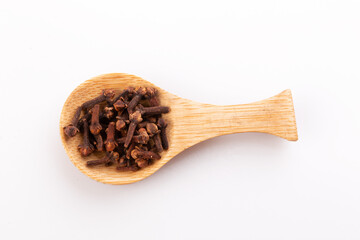 clove seasoning in a wooden spoon isolated on a white background
