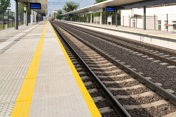Fototapeta premium Yellow lines at the train station on sunny day in the city