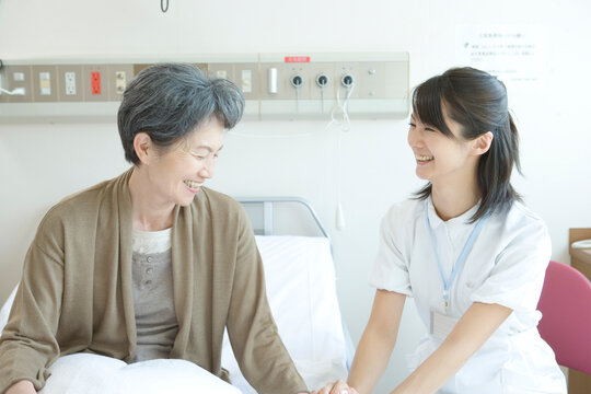 年配患者と話す看護師