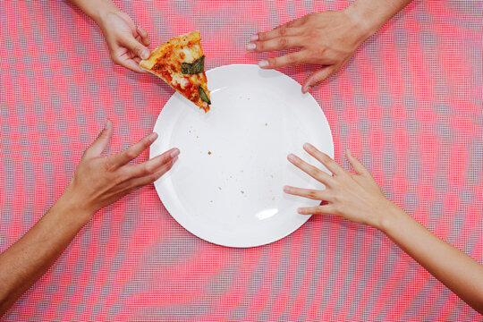 1ピースのピザに伸びる4つの手