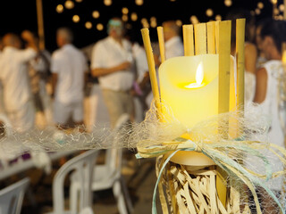 Adornos con velas encendidas en una fiesta con personas vestidas de blanco en la playa de Malaga la Noche de San Juan
