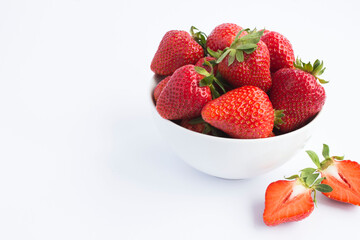 Strawberry in the white bowl on the white background. Closeup.