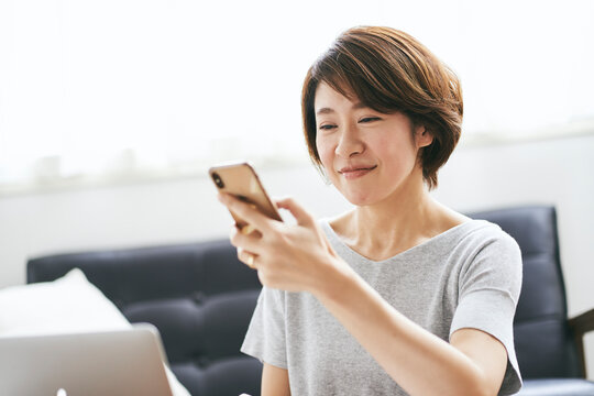 スマートフォンを見る40代日本人女性