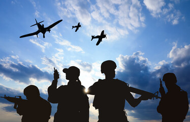 Silhouettes of soldiers in uniform with assault rifles and military airplanes patrolling outdoors