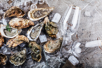 top view of delicious oysters on ice cubes and wine glass
