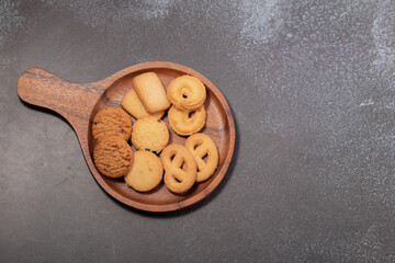 Cookies in a wooden plate on a black background