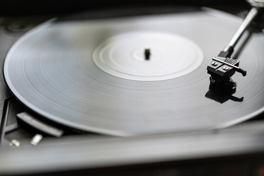 A black vinyl record is spinning on a vintage record player