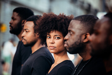 Black people on street with serious expression. The woman is looking at camera