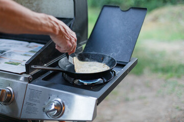 Making crêpes on gas burner with cast iron pan