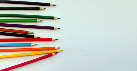 Colored pencils on white background. Lots of different colored pencils. Colored pencil. Pencils sharp. Pencils lie on the left. Beautiful background. Close-up. Copy space. Background. Banner