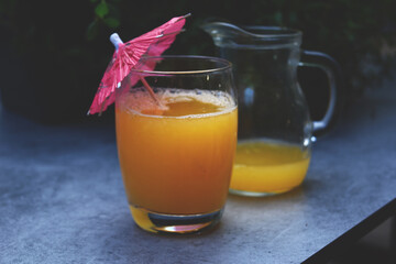 Freshly squeezed orange juice in a glass, decorated with an umbrella