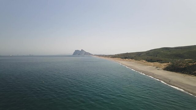 Aerial view of Spanish beach with rock of Gibraltar on sight, trucking right