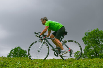 Fototapeta premium Riding adult cyclist on his road bicycle in a park