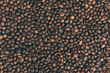Background from dark coffee beans close-up on the table.