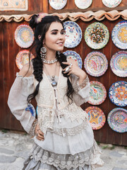 Beautiful women in the old city.Outdoor portrait of pretty brunette.Girl wearing stylish boho chic outfit.Fashion girl wearing bohemian clothing posing in the old city street. Boho chic fashion style.