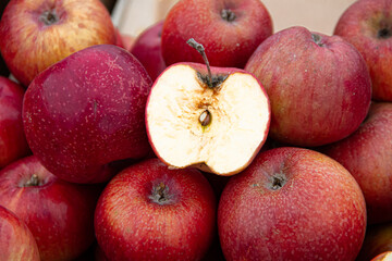 Whole and half cut red apples in the stand