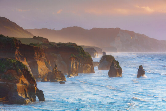 Rock formations called ‚Äö√Ñ√∫three sisters‚Äö√Ñ√π near Tongaporutu along the west coast of the North Island at sunset