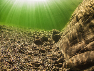 Underwater scenery in river Maggia / Switzerland / Europe with magical sun beams