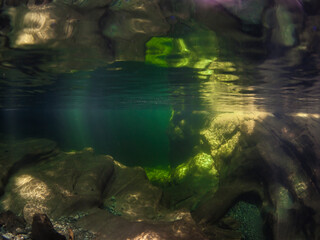 Underwater scenery in river Maggia / Switzerland / Europe with magical sun beams