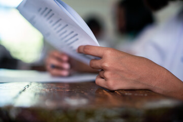 Students doing exam answer sheets exercises in classroom of school
