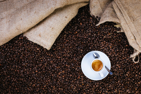 Directly above shot of espresso cup on roasted coffee beans
