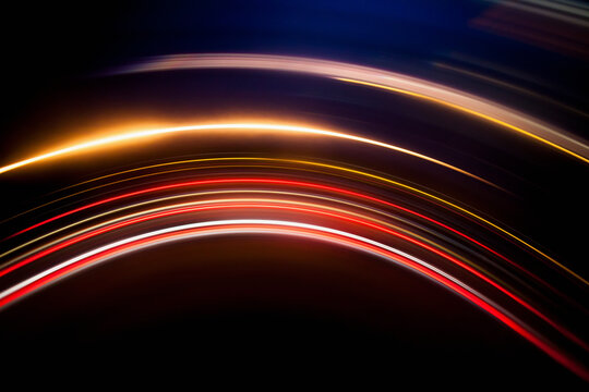 Full frame abstract image of vibrant light trails against black background