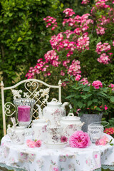 Gartenszene im Sommer mit vintage Porzellan und pink Rosen
