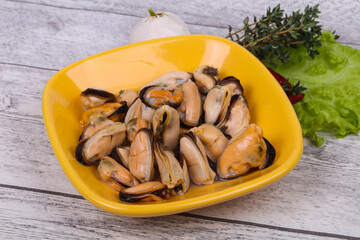 Pickled mussels in the bowl served pepper, garlic and salad