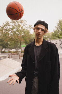 Portrait of young man playing basketball in park
