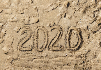 Summer vacation 2020. The inscription, the words written, drawn on the sea sand, top view. Photograph, copy space.