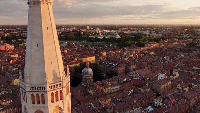 modena city aerial view drone flying close to  ghirlandina tower with cityscape in the background at sunrise