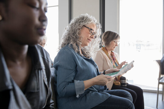 Woman reading brochure in conference audience