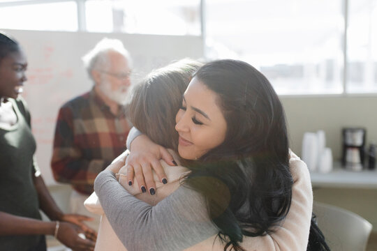Women hugging each other at support group meeting