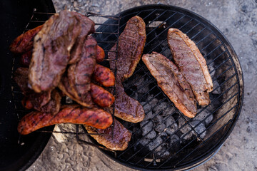 Top view of a portable BBQ with meats while camping in Canada