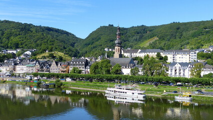 Fototapeta premium Cochem an der Mosel und sich in der Mosel spiegelnde Schiffe an der Anlegestelle