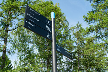 Gray post direction indicator in the park. Indicate Visit Hall, Basktball, Ramp, Amphitheater.