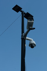 Surveillance cameras on a high pole with backlight.