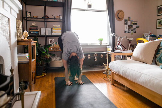 Young Woman Doing Yoga In Living Room