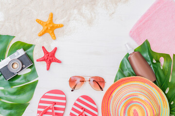 Flat lay composition with a summer hat and flip flops on a light background