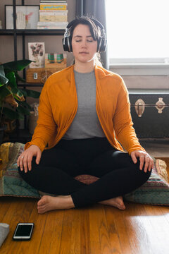 Young Woman Listening To Guided Meditation On Phone