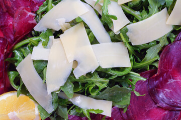 Platter with bresaola dried beef, arugula salad and parmesan cheese