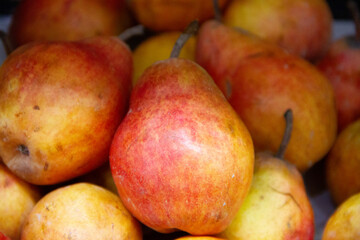 Red and yellow colored pears in the stock
