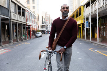 Fototapeta na wymiar African American man riding a bike in the city street
