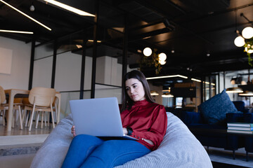 Caucasian woman working on her laptop in a bean bag 
